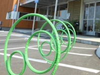 Green circle bike racks outside of Three Rivers Market