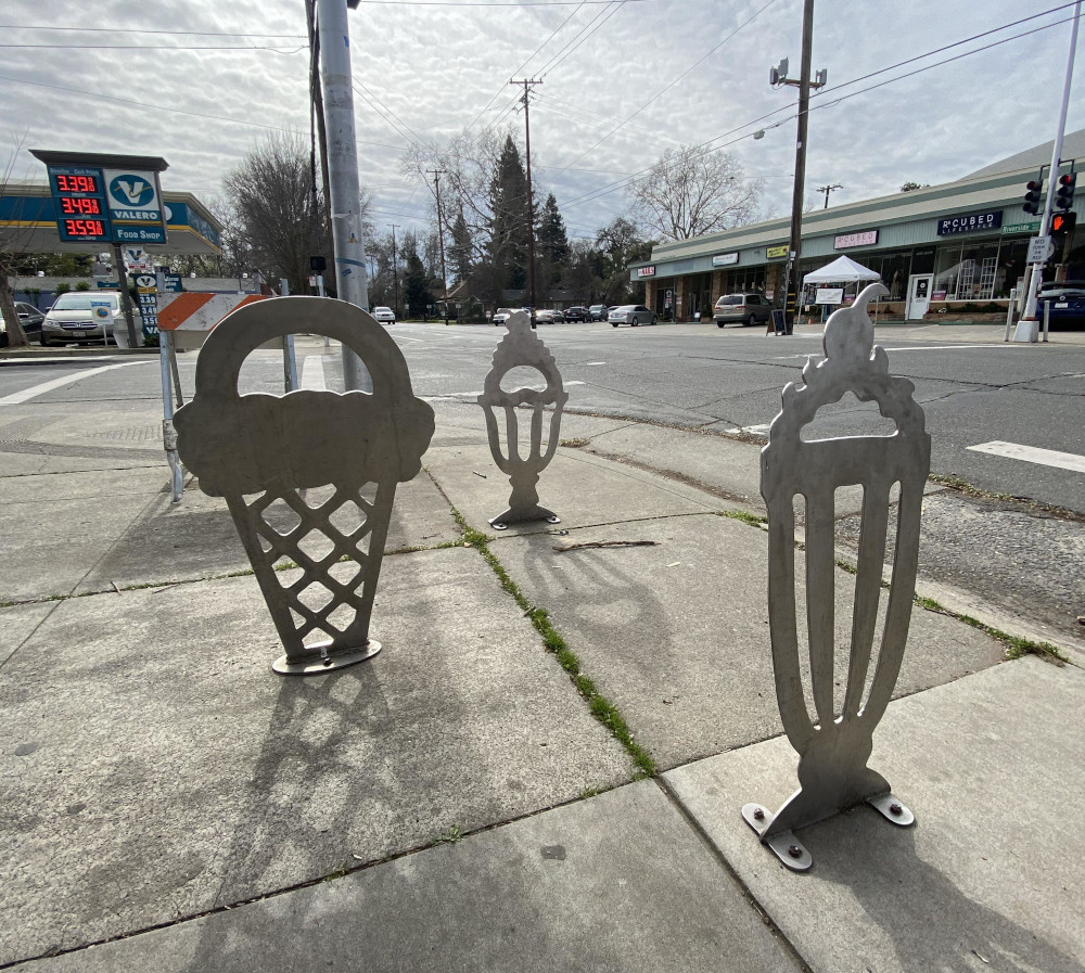 Three bike racks in the shape of ice cream cupa and cones